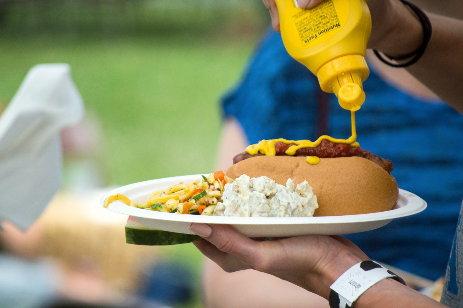 Putting mustard on a veggie dog at a Farm Sanctuary Pignic